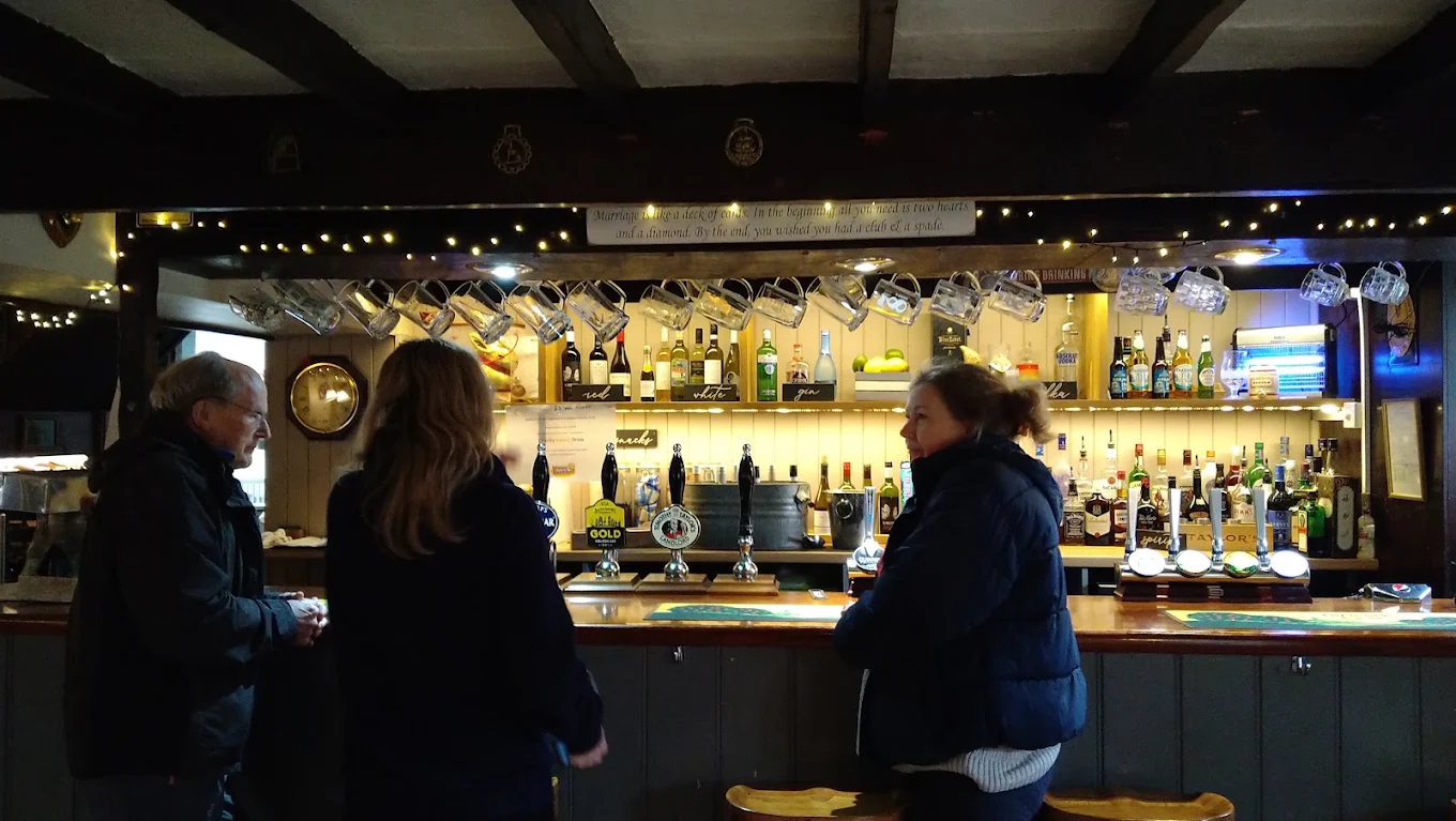 Regulars at the bar beneath fairy-lit beams and hanging tankards